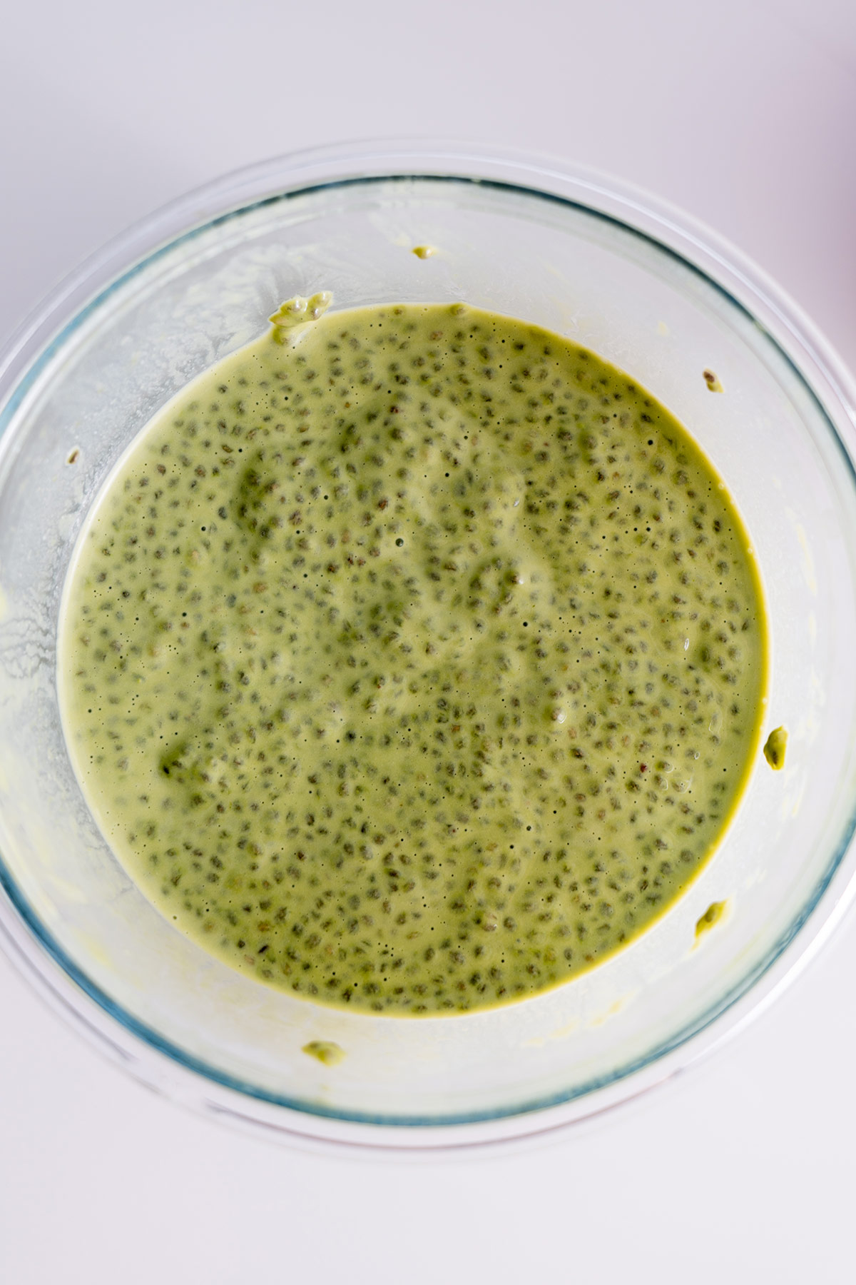Top view of matcha chia pudding mix in a glass bowl.