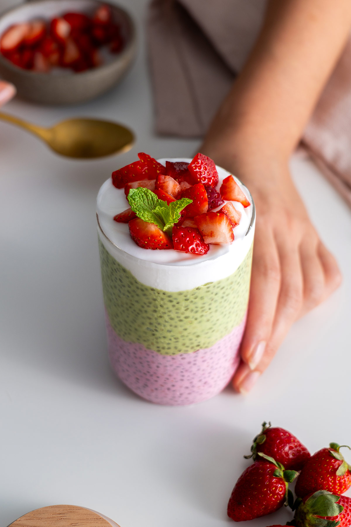 Top-down view of strawberry matcha chia pudding garnished with fresh strawberries.