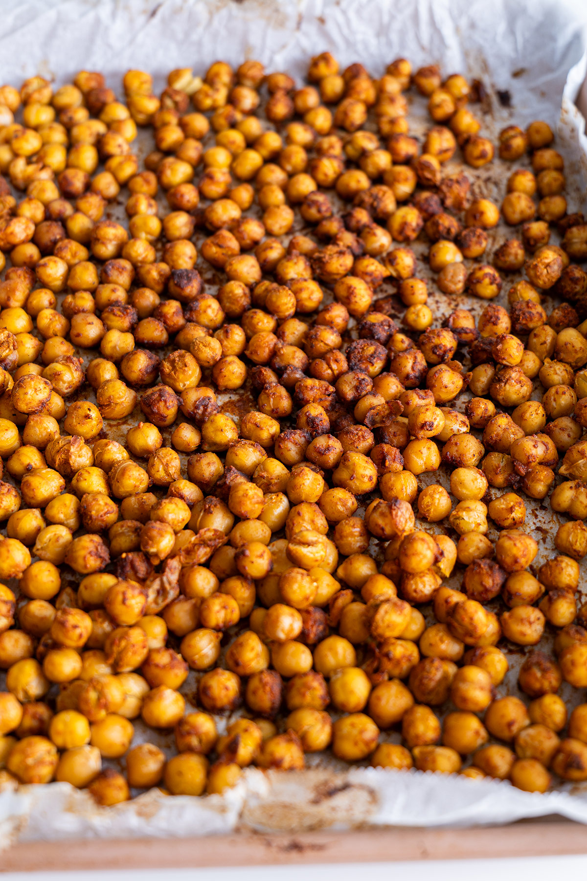 Spiced roasted chickpeas spread out on a parchment-lined tray.