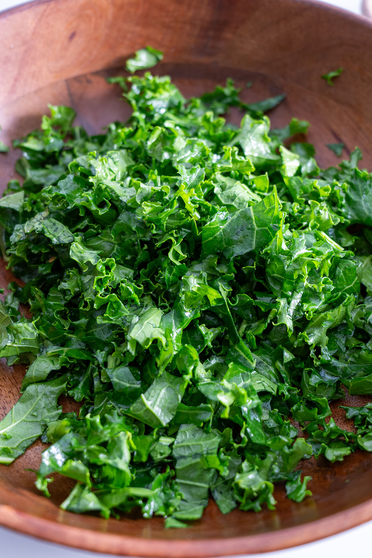 Freshly chopped kale in a wooden bowl.
