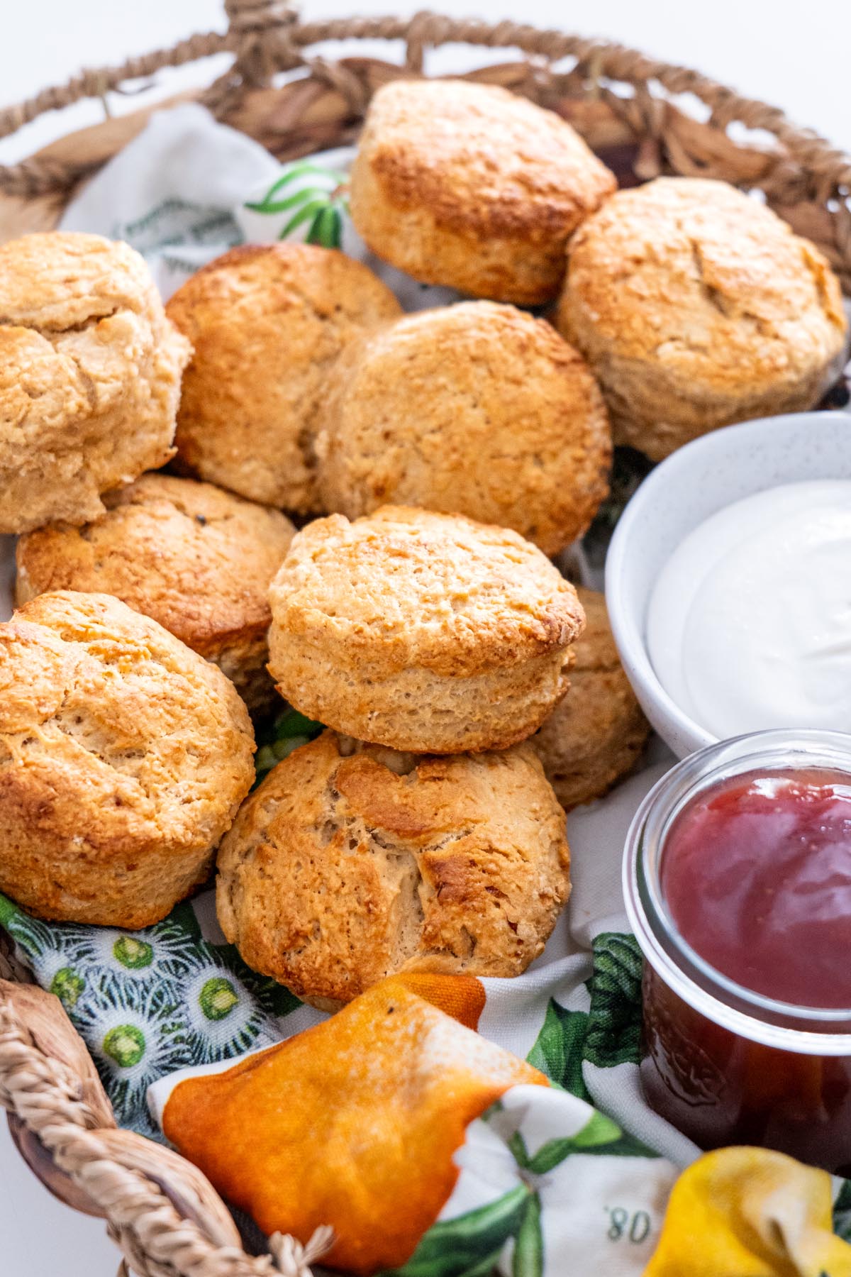 Vegan scones served in a rustic basket with condiments and a white napkin.