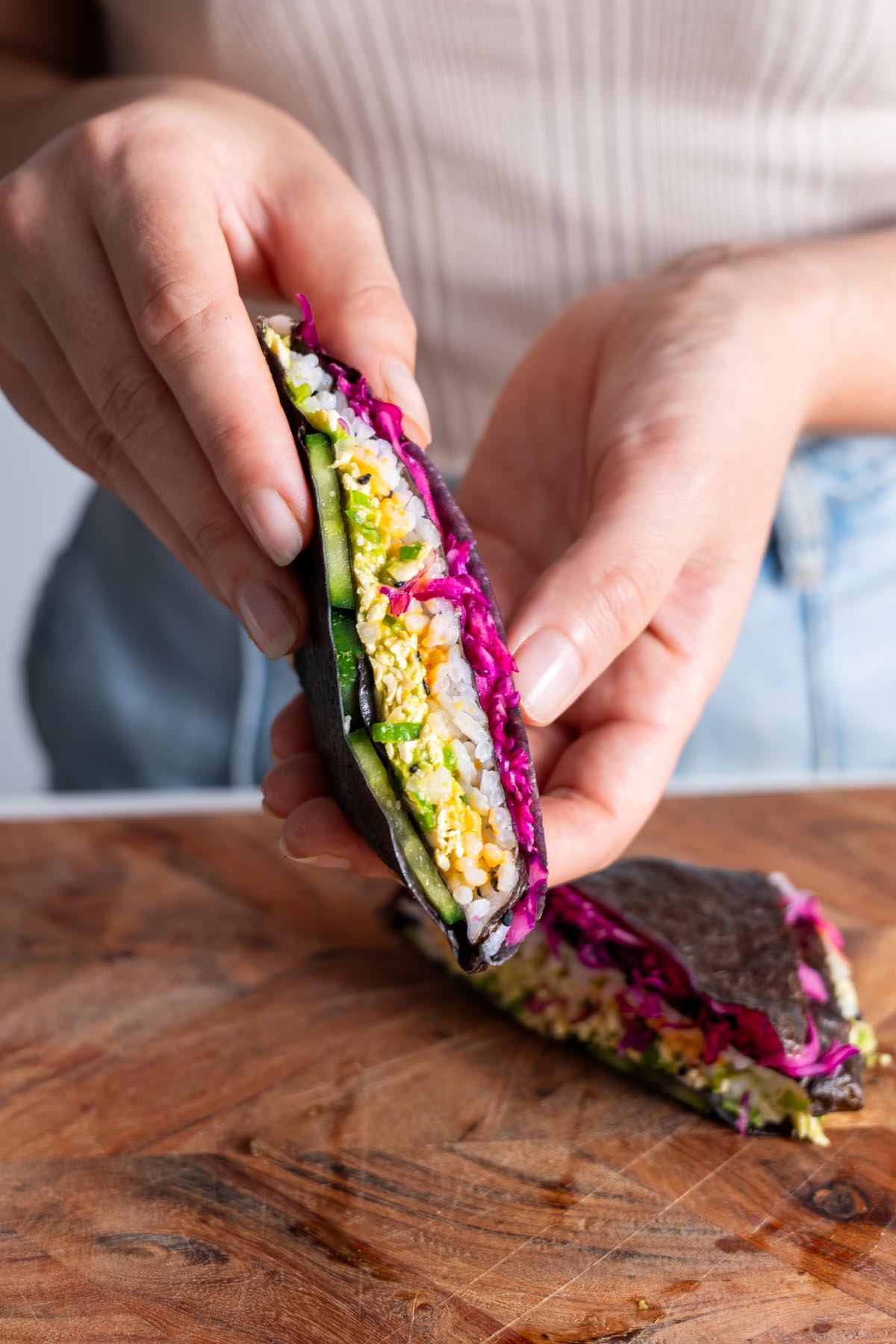 Sarah holding a completed veggie sushi wrap, ready to eat.