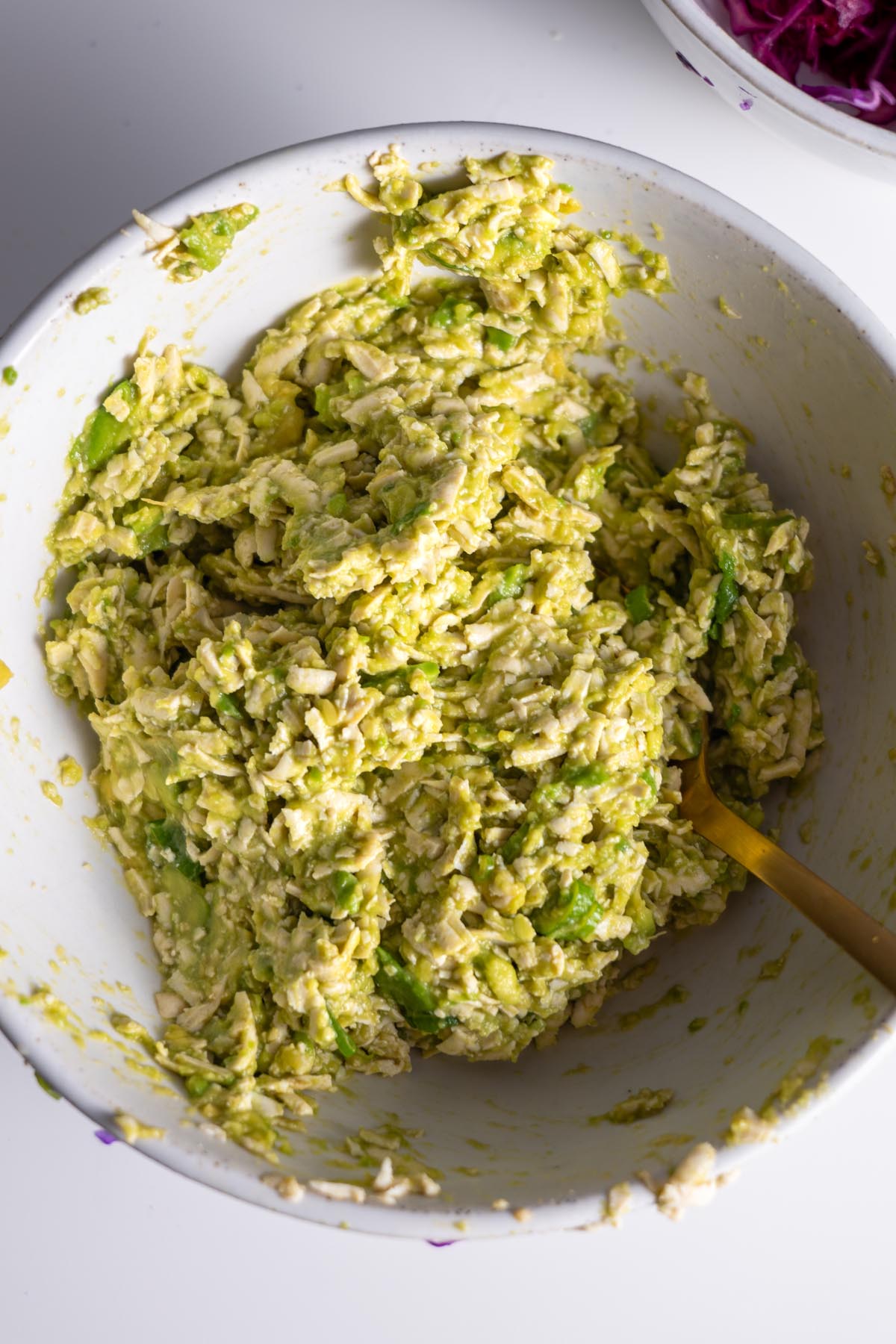 Mixing avocado and tofu mixture in a bowl for sushi wrap filling