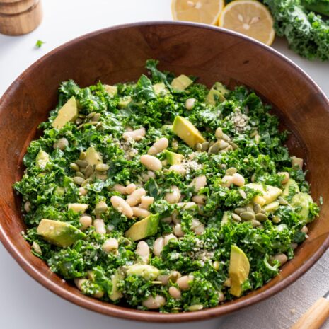Erewhon kale salad in a wooden bowl, close-up view.