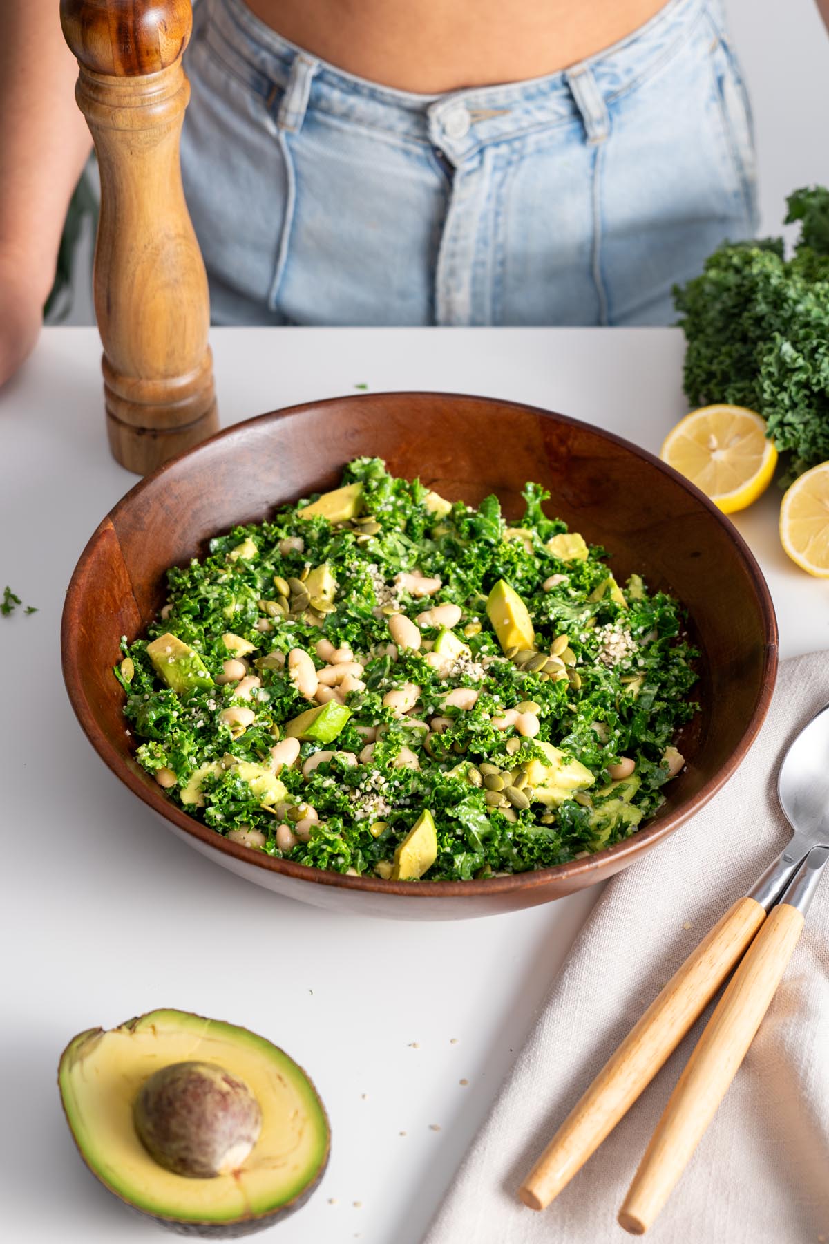 Erewhon kale salad in a wooden bowl with fresh ingredients around it.