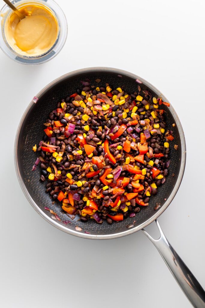 Sautéed black bean and vegetable mixture in a frying pan