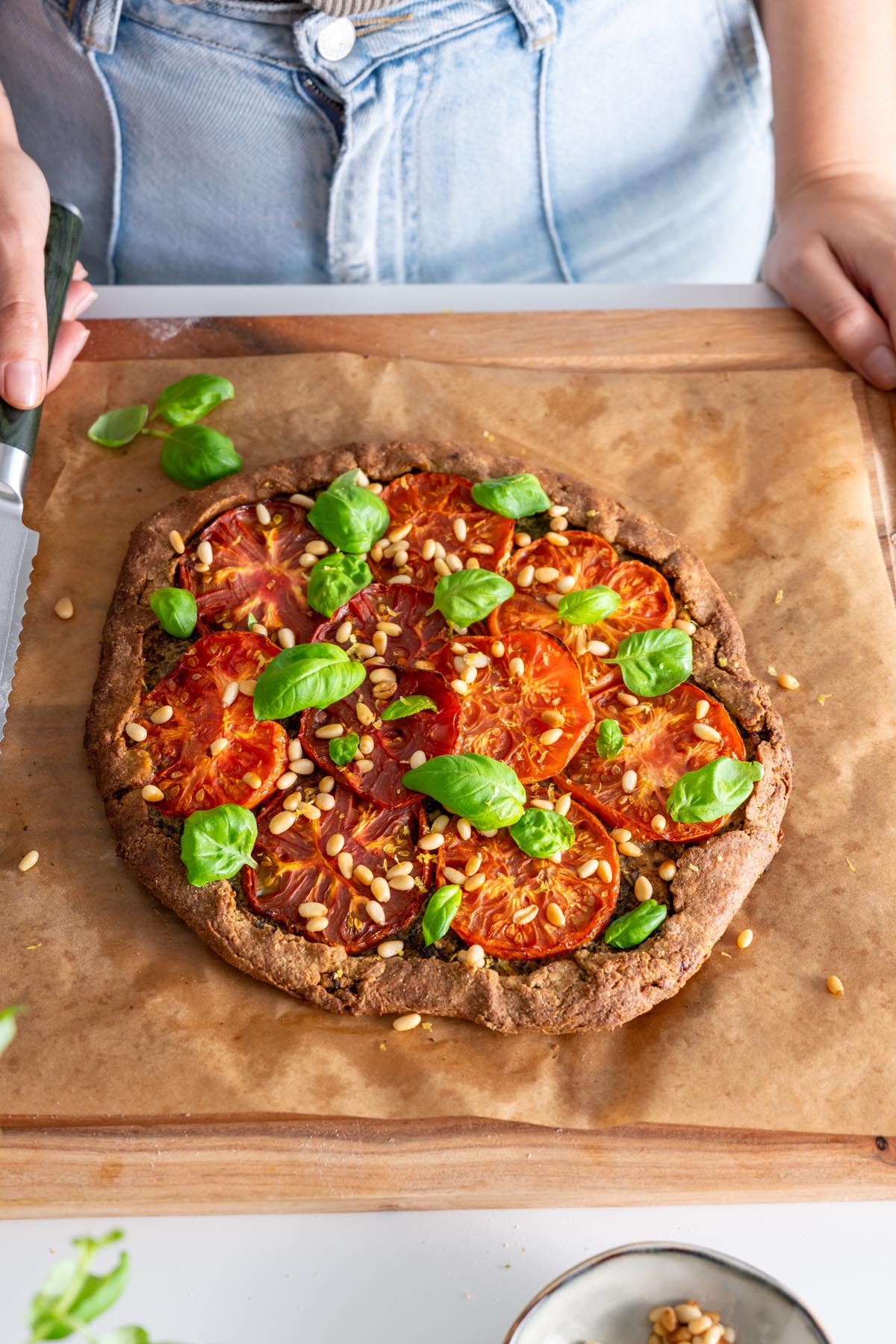 Finished Pesto Tomato Spelt Galette on a parchment paper-lined baking sheet.