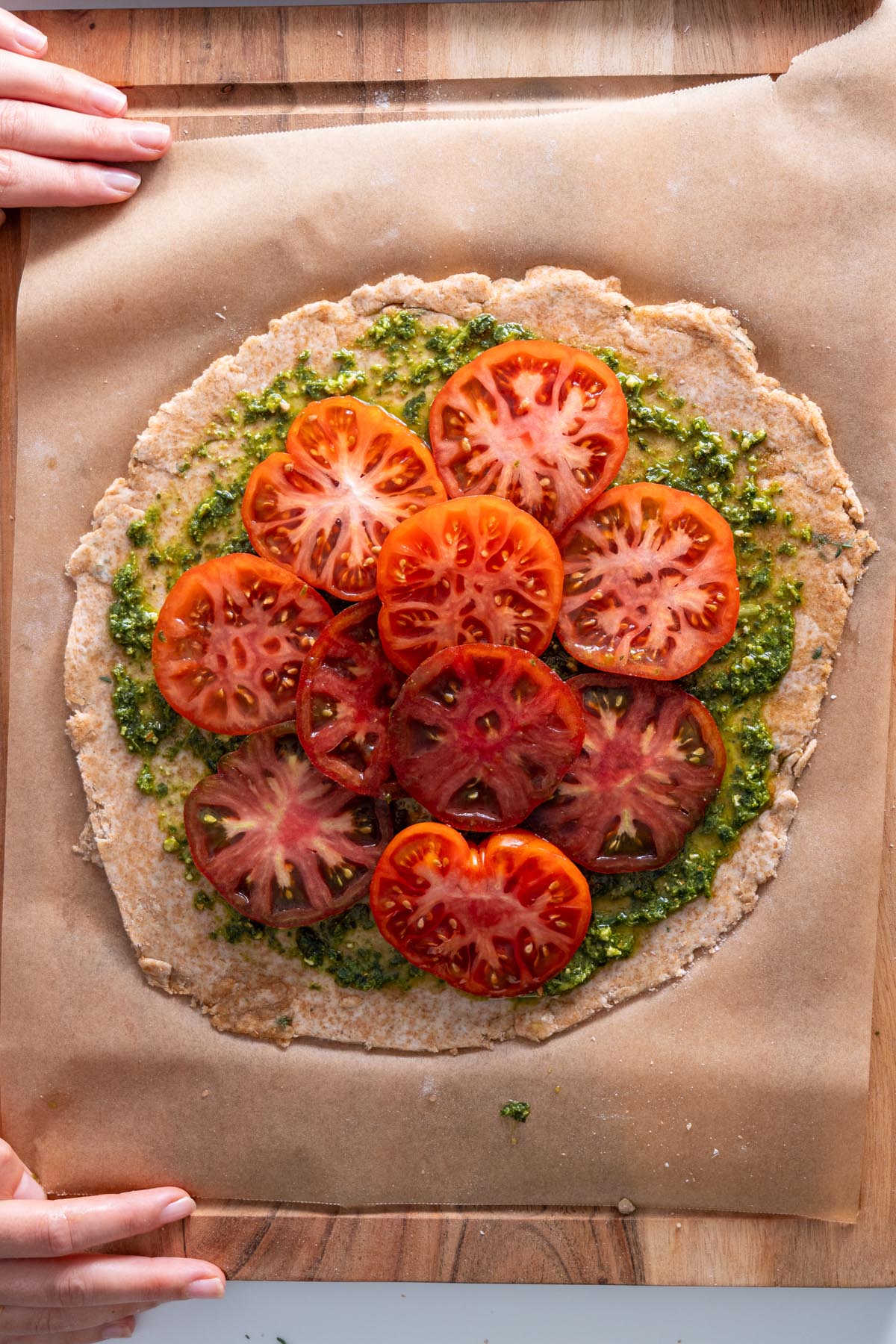 Pesto Tomato Spelt Galette topped with heirloom tomatoes and pesto before baking.