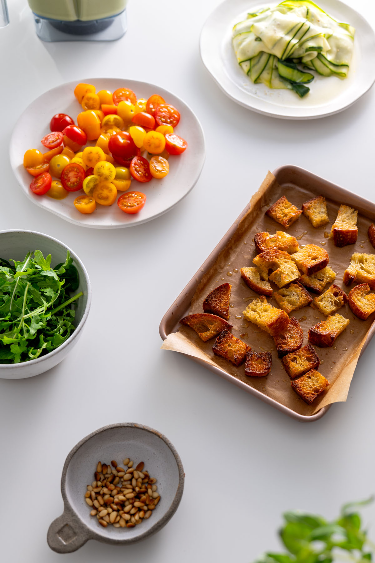 Fresh ingredients, croutons, and pine nuts prepared for assembling the high-protein pesto bowl.