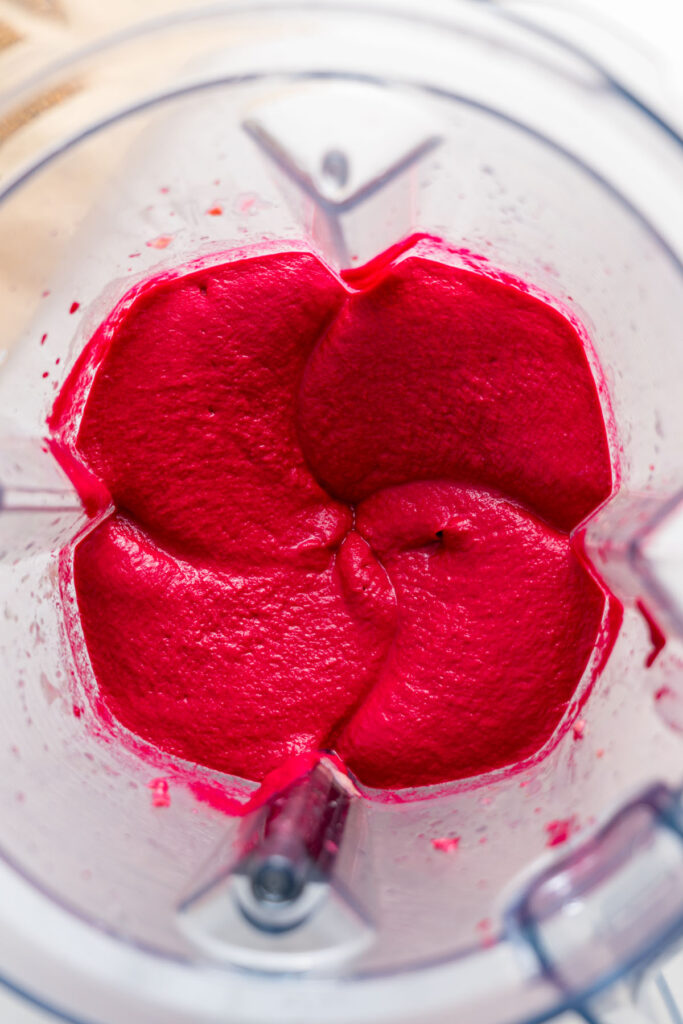 Blended beetroot hummus in a high-speed blender.