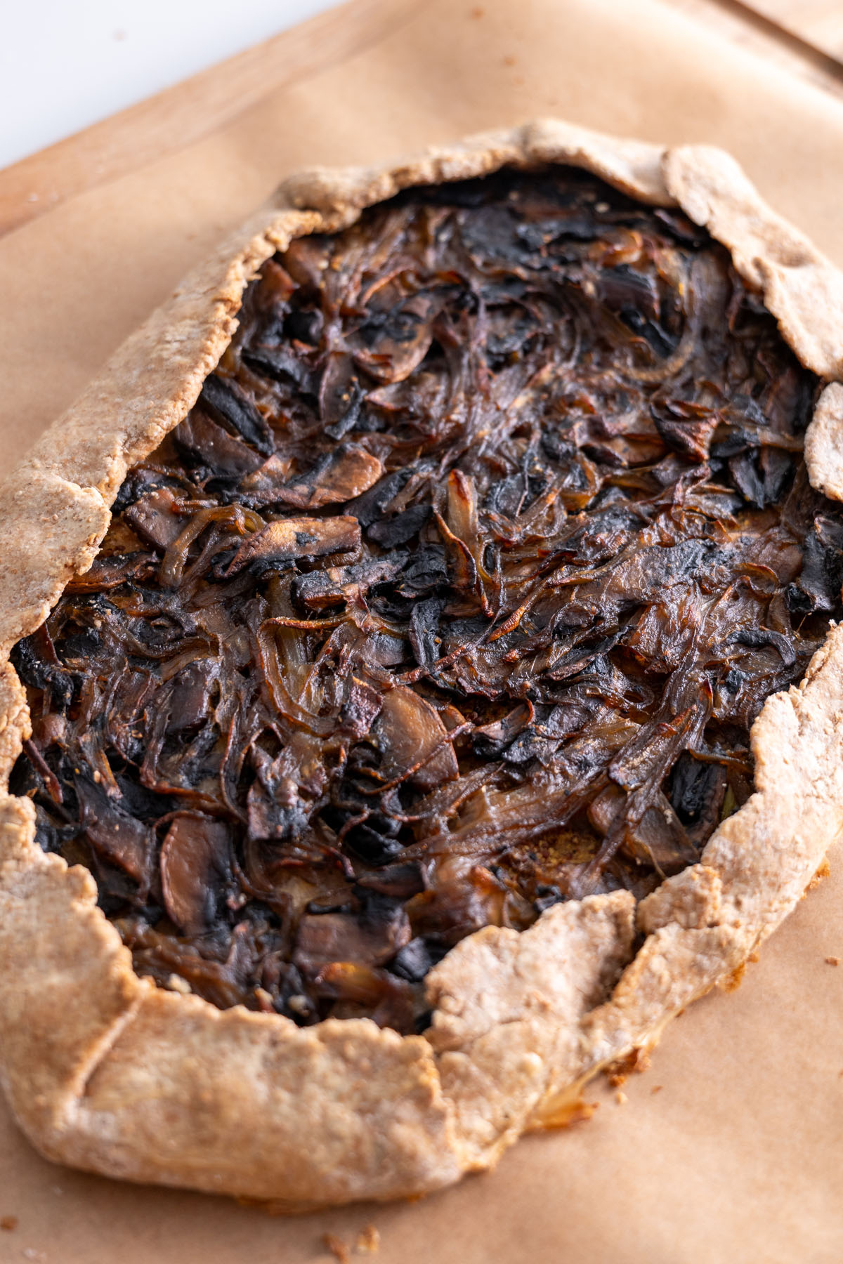 Baked caramelized onion mushroom galette on parchment paper.
