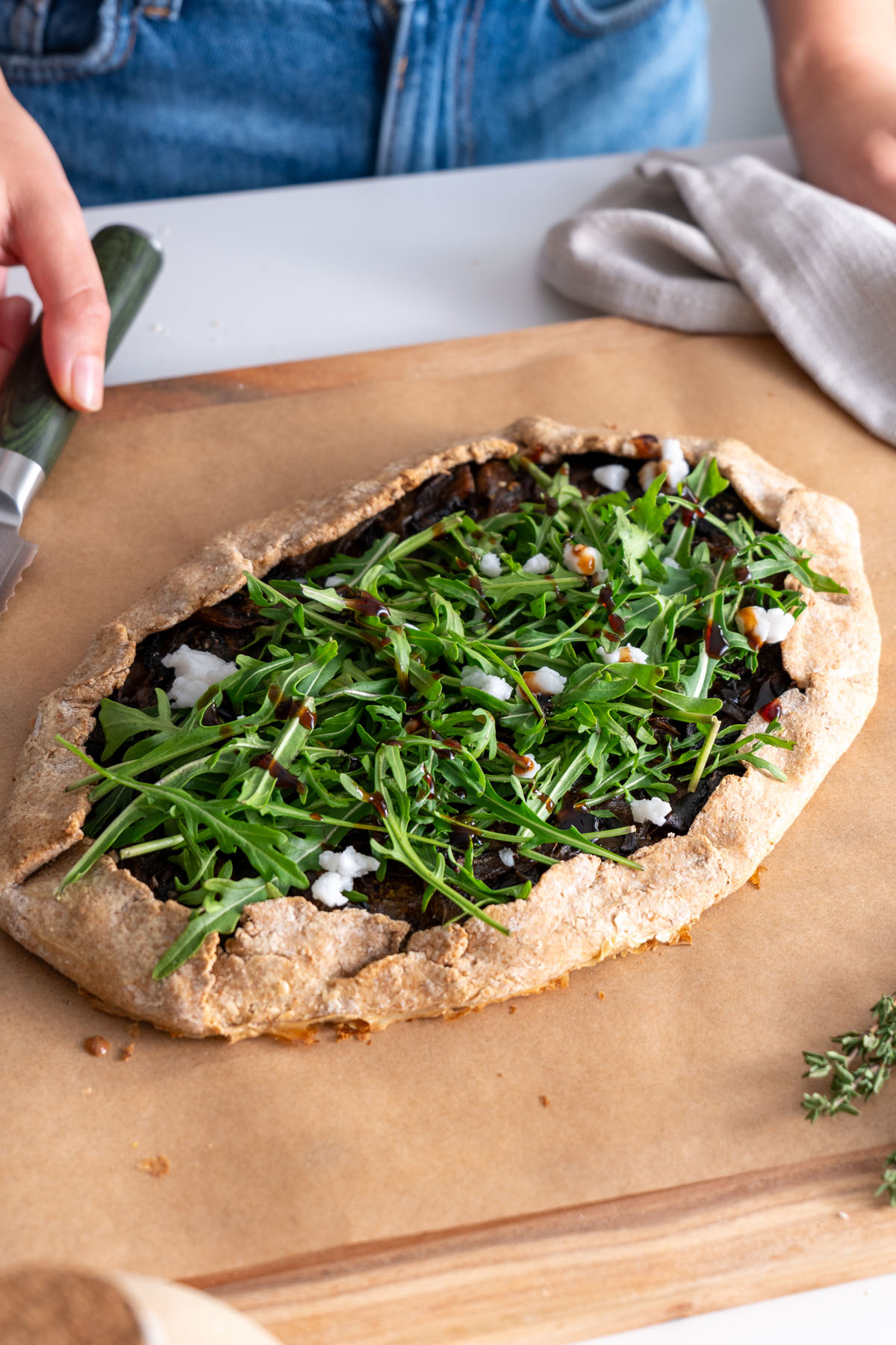 Galette topped with fresh arugula, plant-based feta, and balsamic glaze.