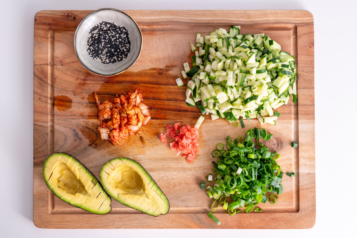 Vibrant ingredients for a High-Protein Vegan Sushi Bowl on a wooden board.