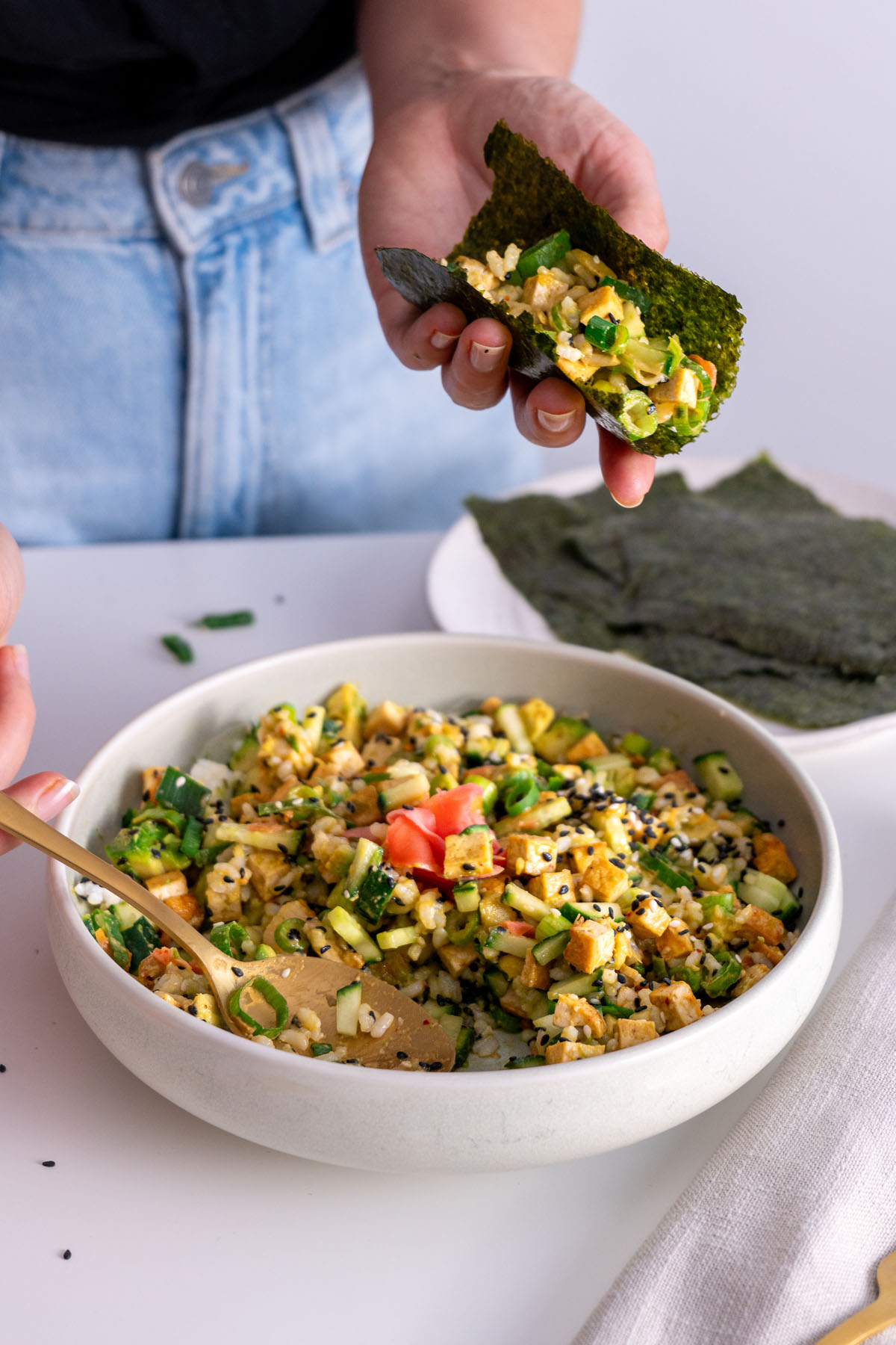 Sarah Cobacho scooping tofu mix into a nori sheet.