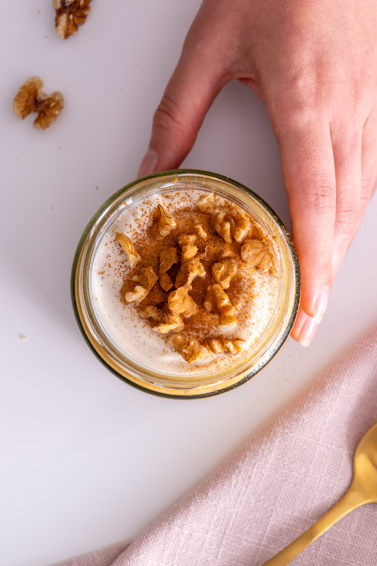 Overhead shot of Sarah Cobacho holding a jar of pumpkin spice overnight oats.