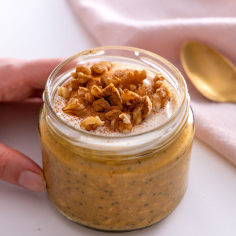 Pumpkin spice overnight oats topped with yogurt and walnuts in a jar