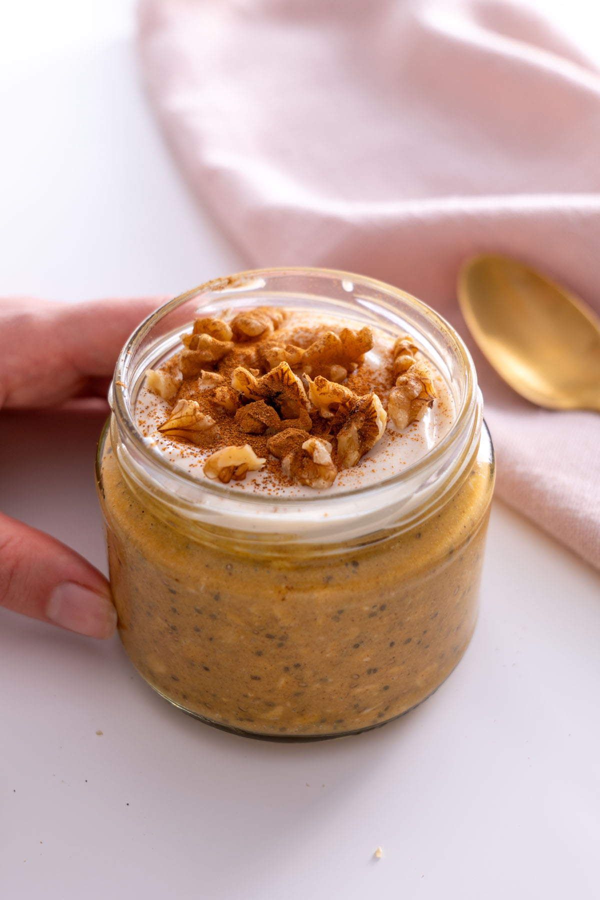 Pumpkin spice overnight oats topped with yogurt and walnuts in a jar