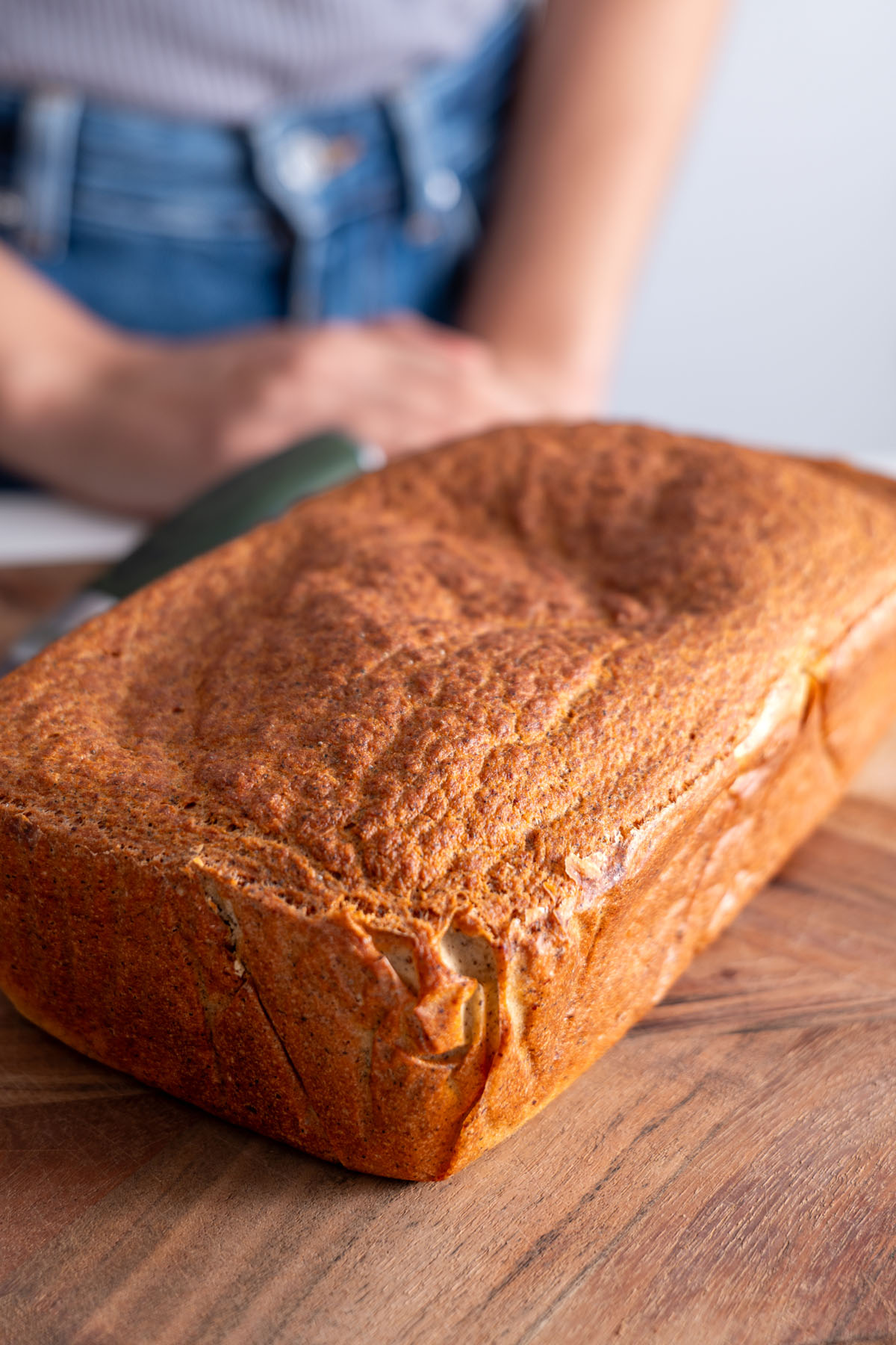 Close-up of the finished red lentil quinoa bread on a wooden surface, ready to slice.