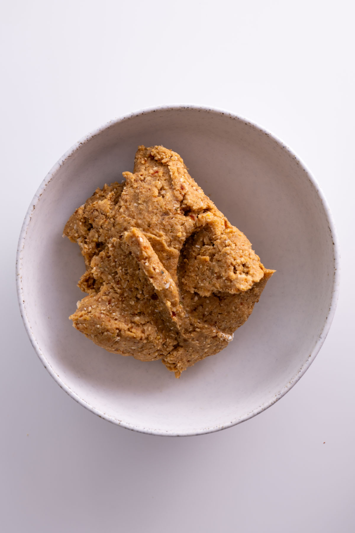 Chickpea cookie dough mixture in a bowl ready to be formed into balls.
