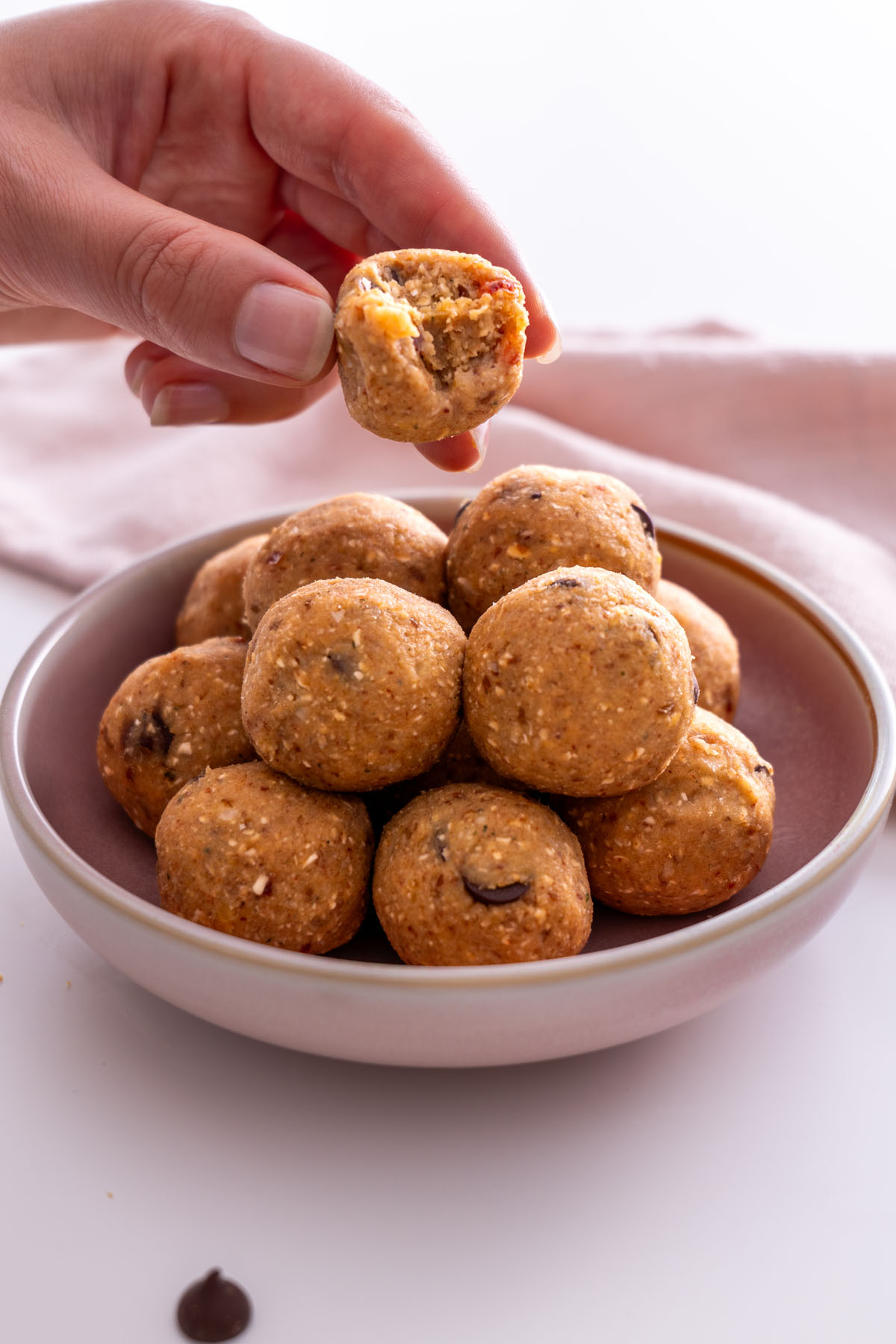 Sarah Cobacho gently stacking chickpea cookie dough bliss balls on a plate.