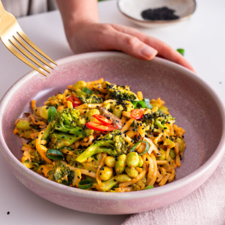 Sarah Cobacho holding a fork over a bowl of peanut gochujang noodles.