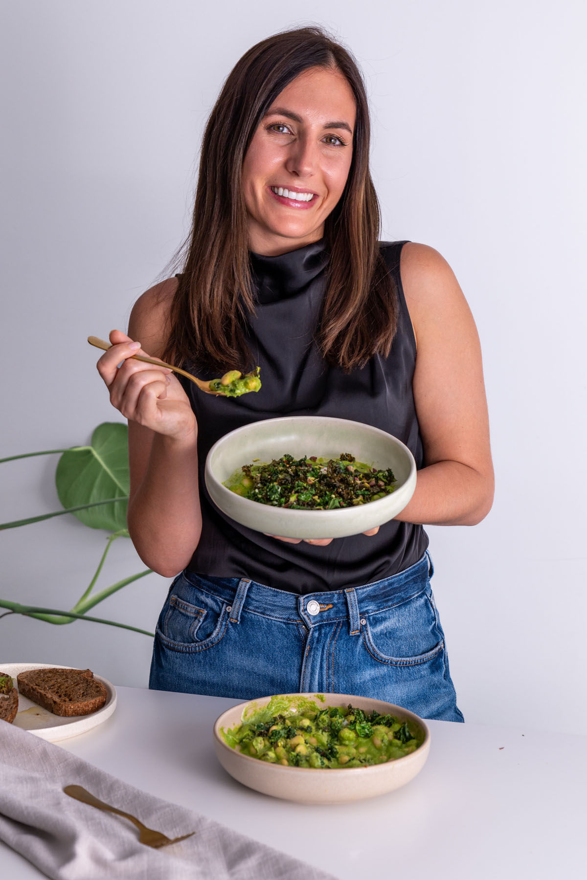 Sarah Cobacho smiling while holding a bowl of Super Green Butter Beans