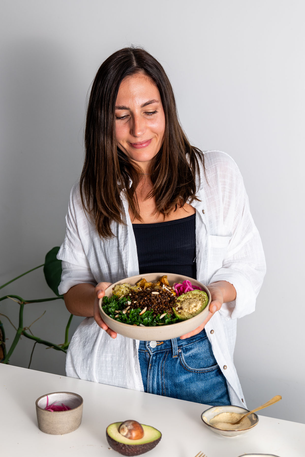 Sarah Cobacho smiling while holding a hearty and nutritious crispy lentil and potato bowl.