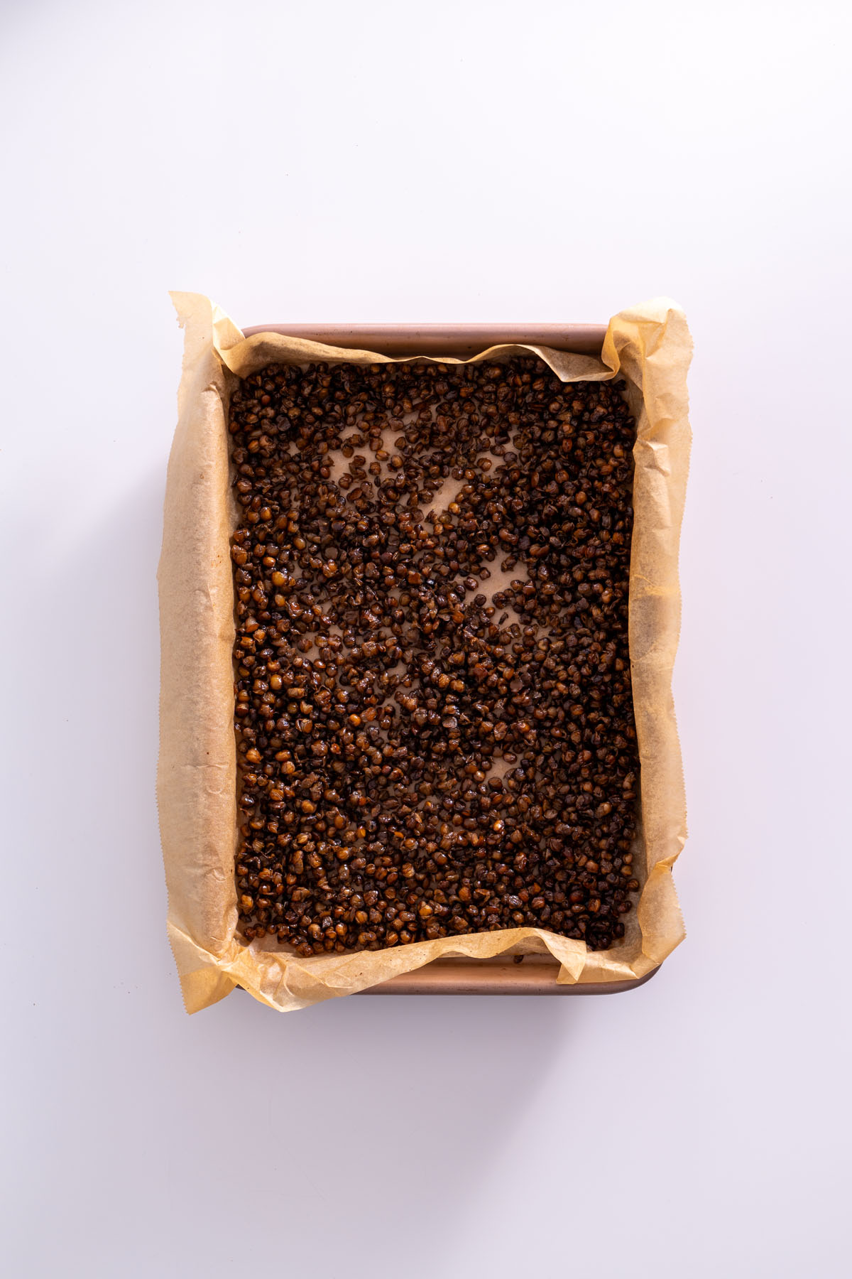 Crispy roasted lentils on a baking sheet, evenly spread out.