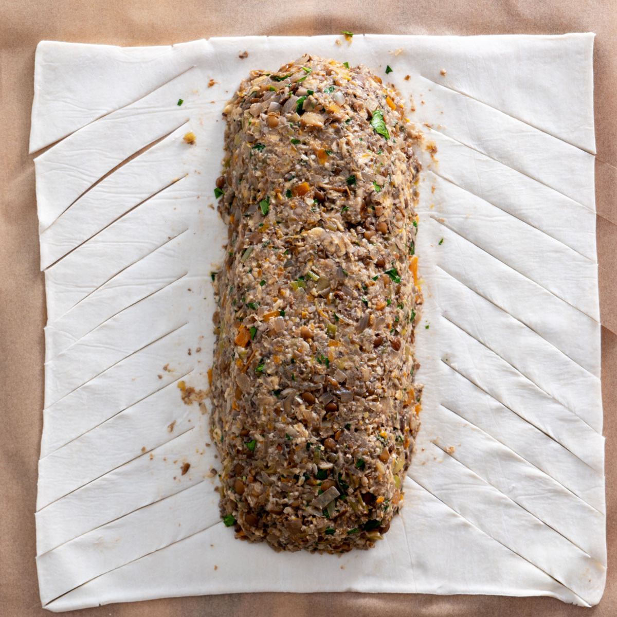 Process shot of mushroom Wellington filling placed on vegan puff pastry, ready for wrapping.