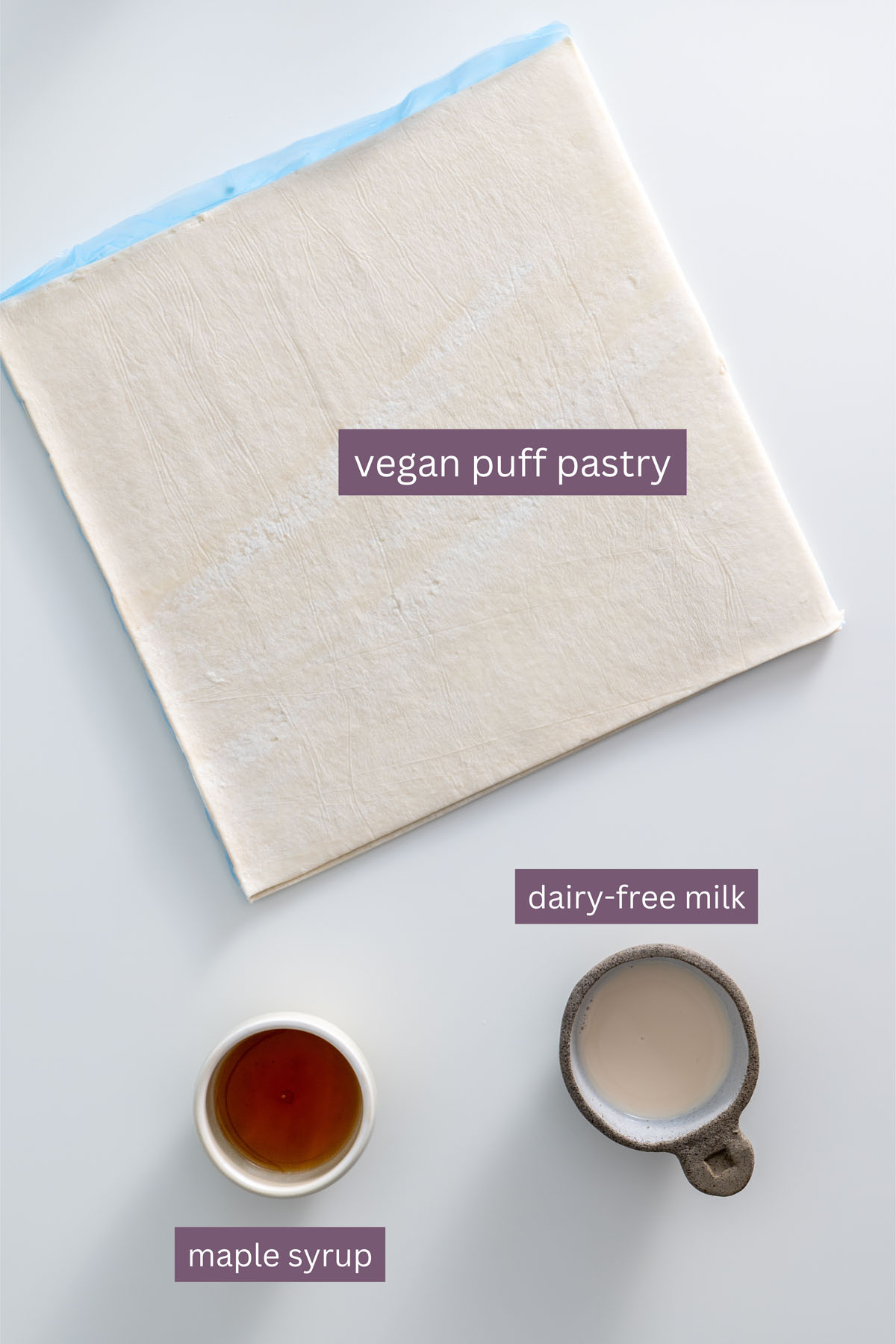 Ingredients for vegan puff pastry with maple syrup and dairy-free milk on a white background.