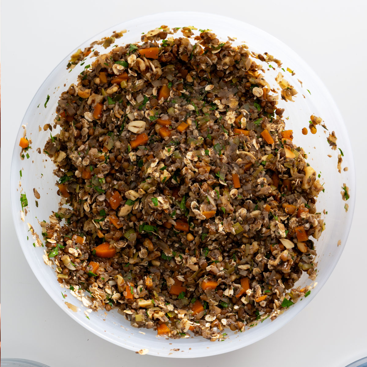 Process shot of mushroom Wellington filling mixture with added oats and nuts in a white bowl.