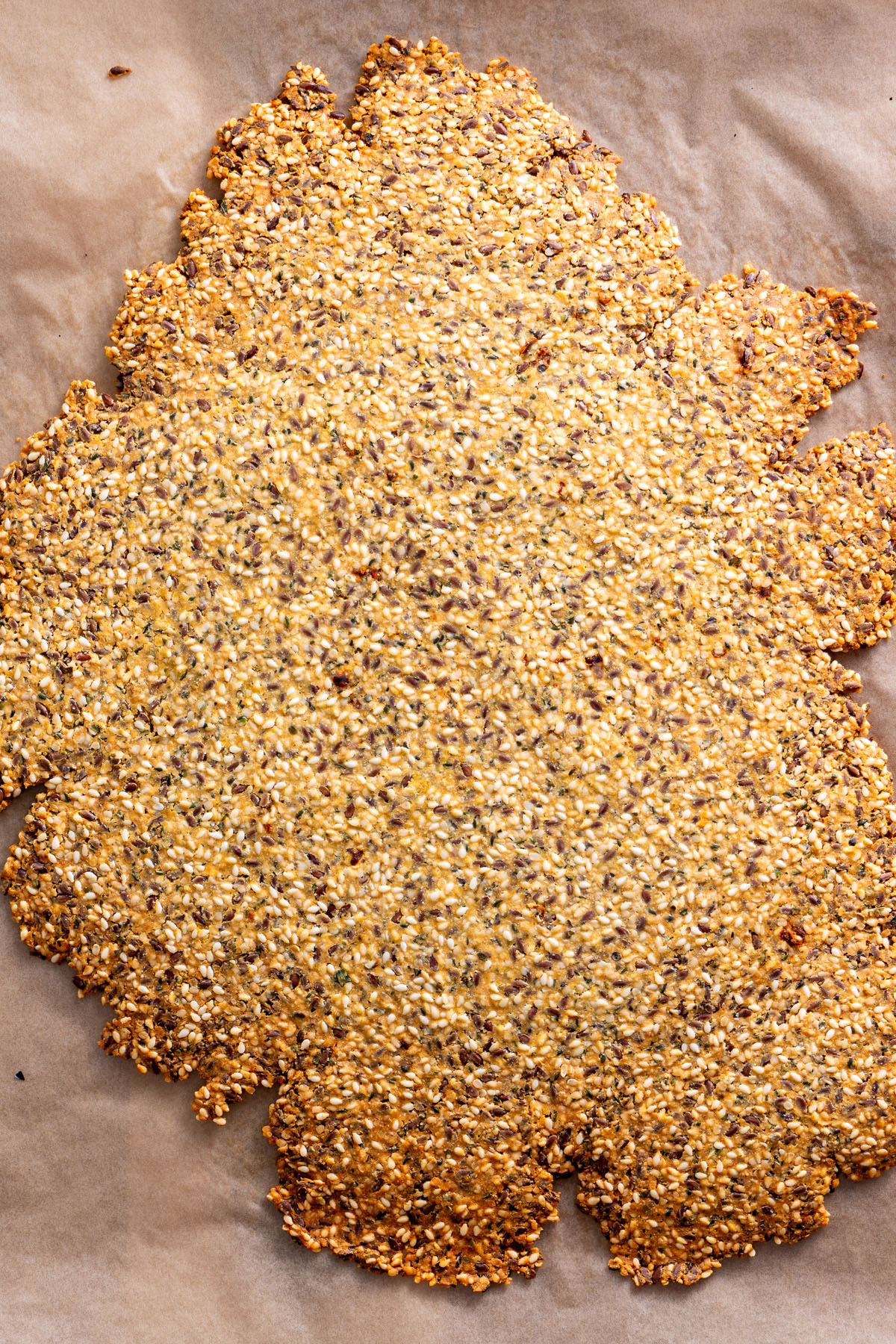 Baked seeded cracker sheet on parchment paper.