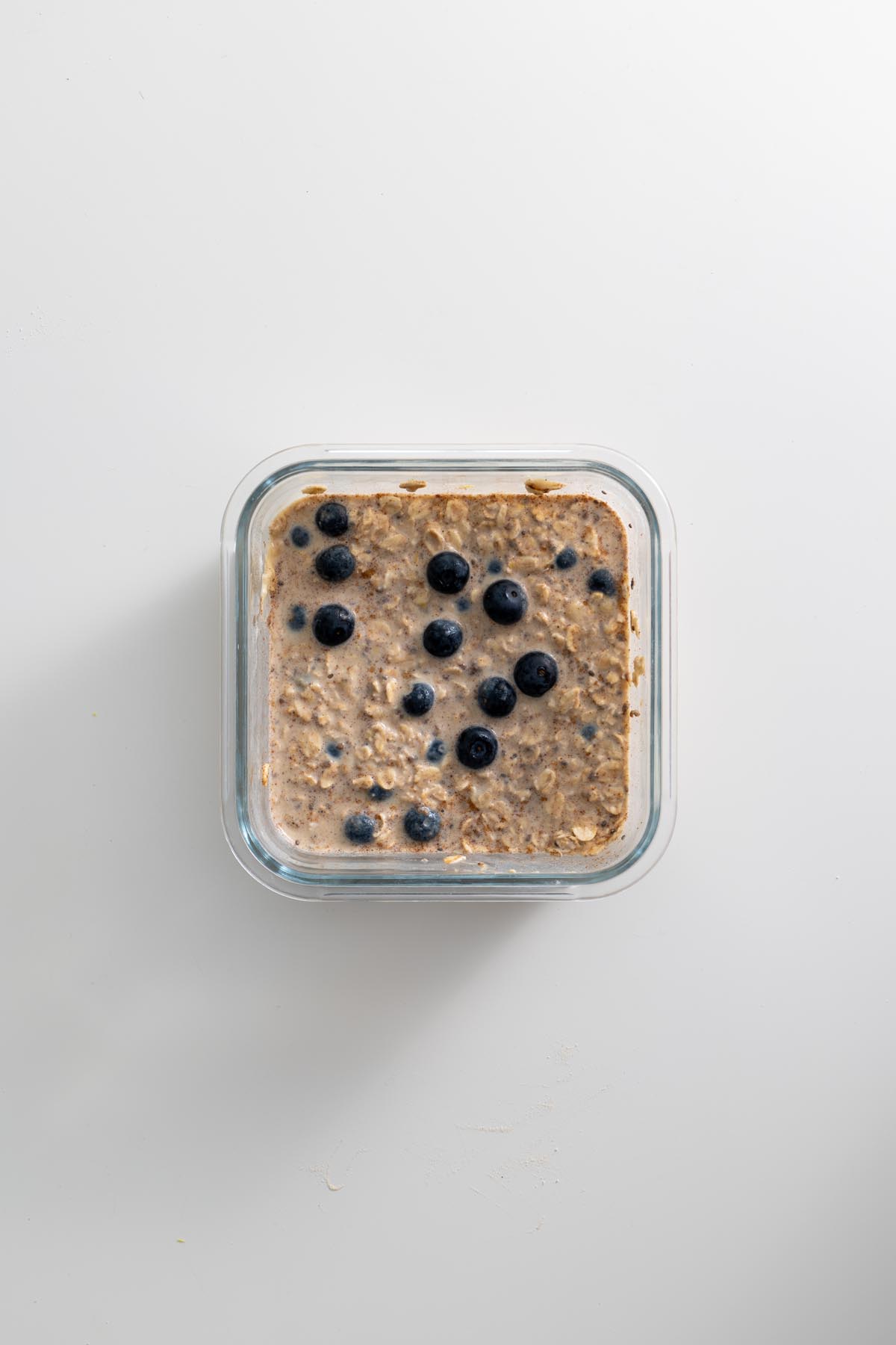 Unbaked High-Protein Blueberry Baked Oats in a glass container