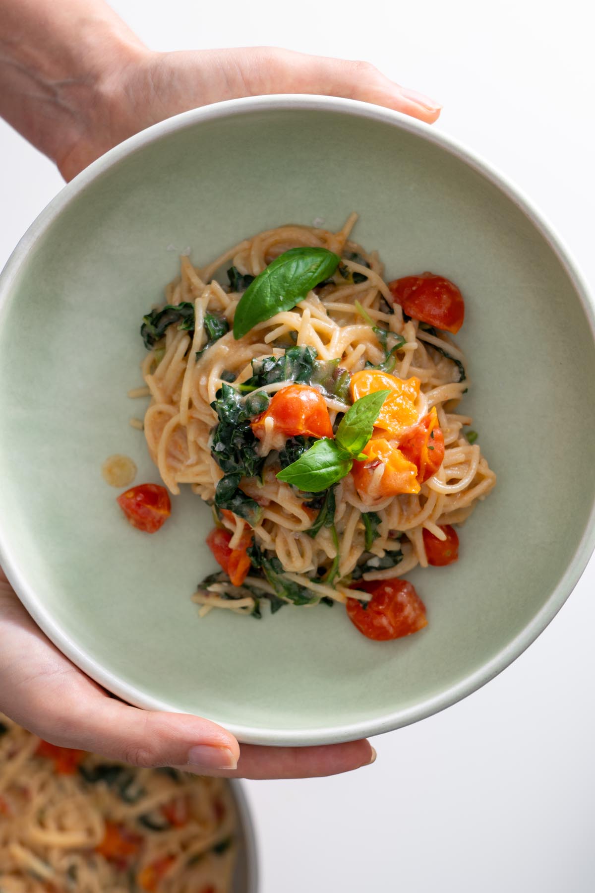 Sarah Cobacho holding a bowl of Meghan Markle’s original one-pot pasta, showcasing the creamy tomato base and fresh basil garnish.