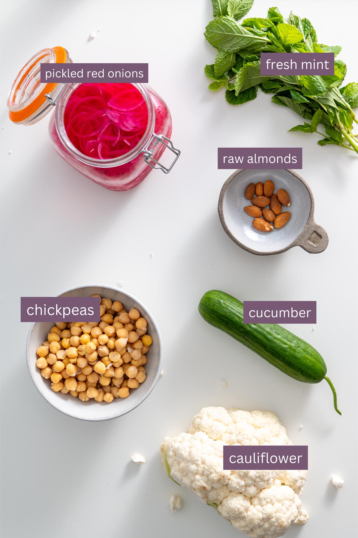 Vibrant ingredients for a tandoori spiced cauliflower bowl on a white surface.
