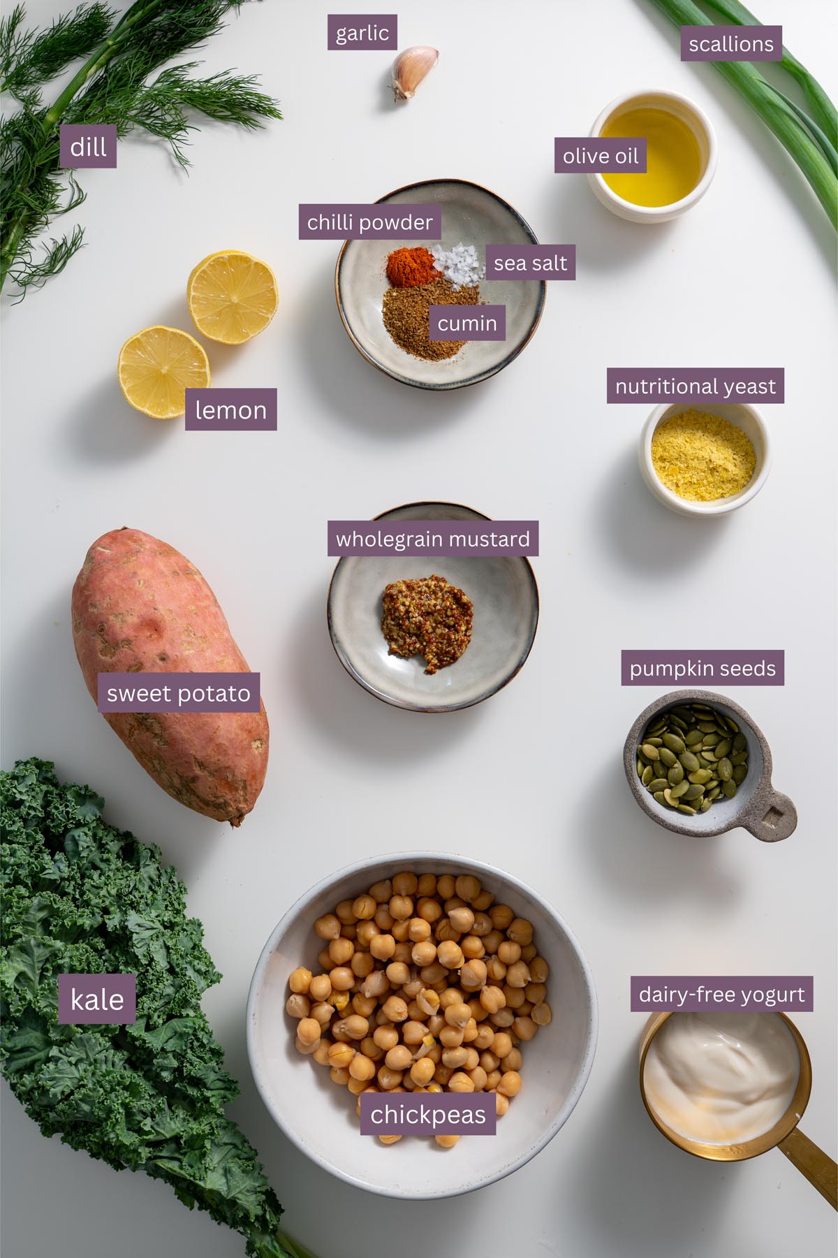 Vibrant ingredients for a kale sweet potato bowl on a white surface.