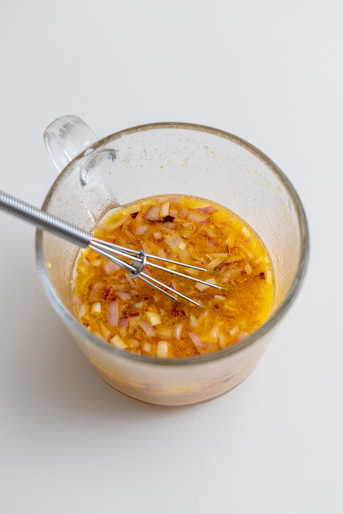 Cooked quinoa fluffed in a white bowl
