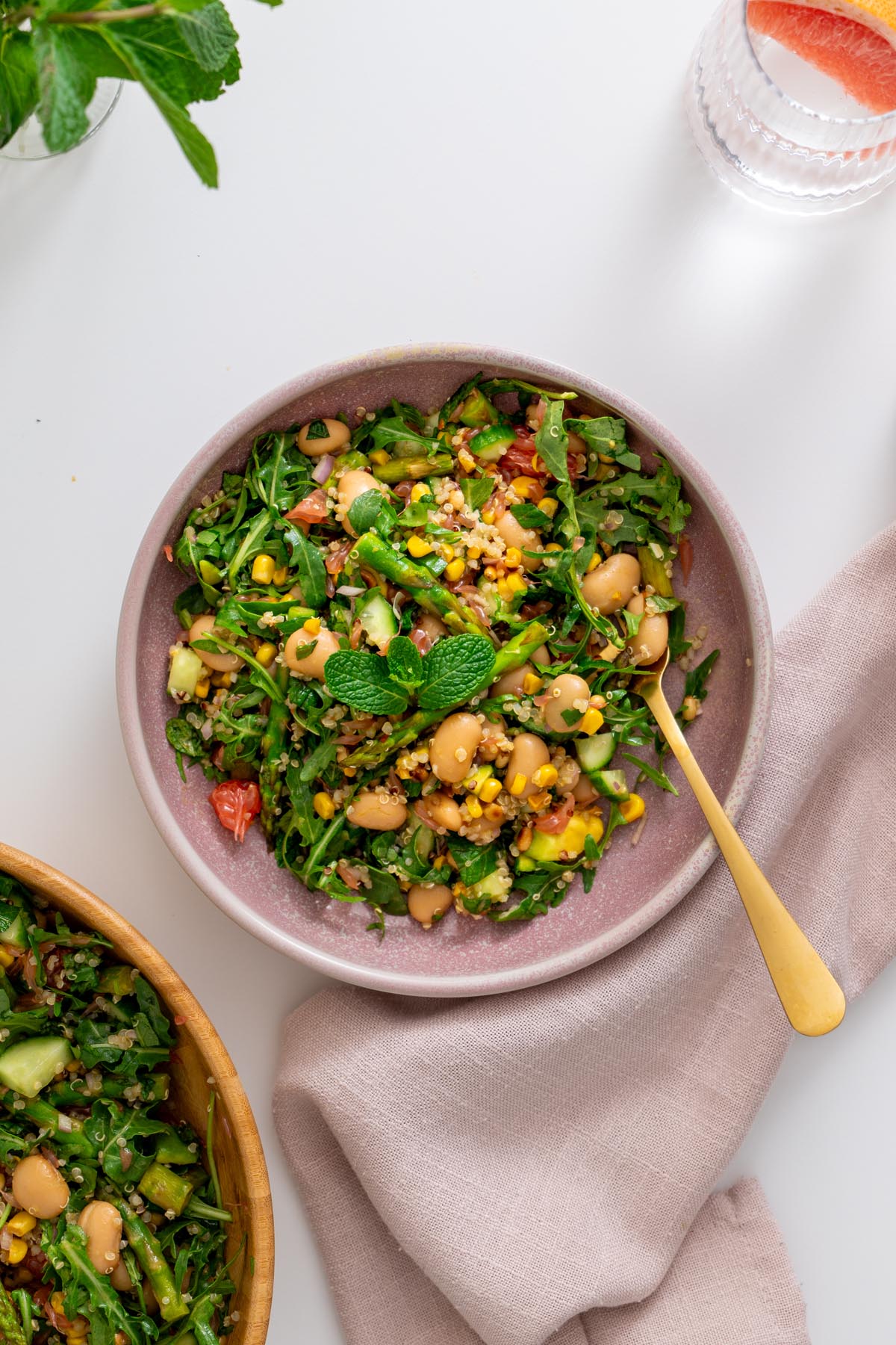 Primavera quinoa salad served in a bowl with vibrant colors from grapefruit, avocado, and herbs