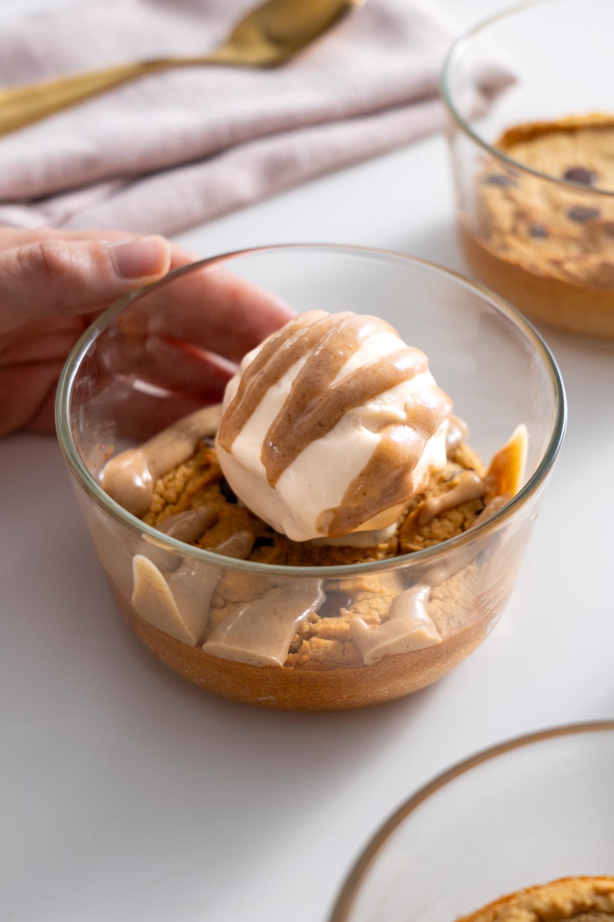 Finished chickpea cookie bowl topped with ice cream and caramel, ready to eat.