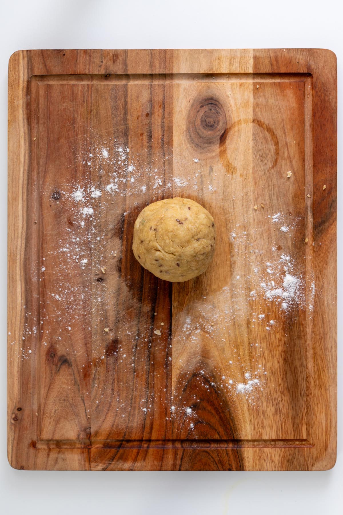 Rolled-out pie crust dough on a wooden surface with rolling pin