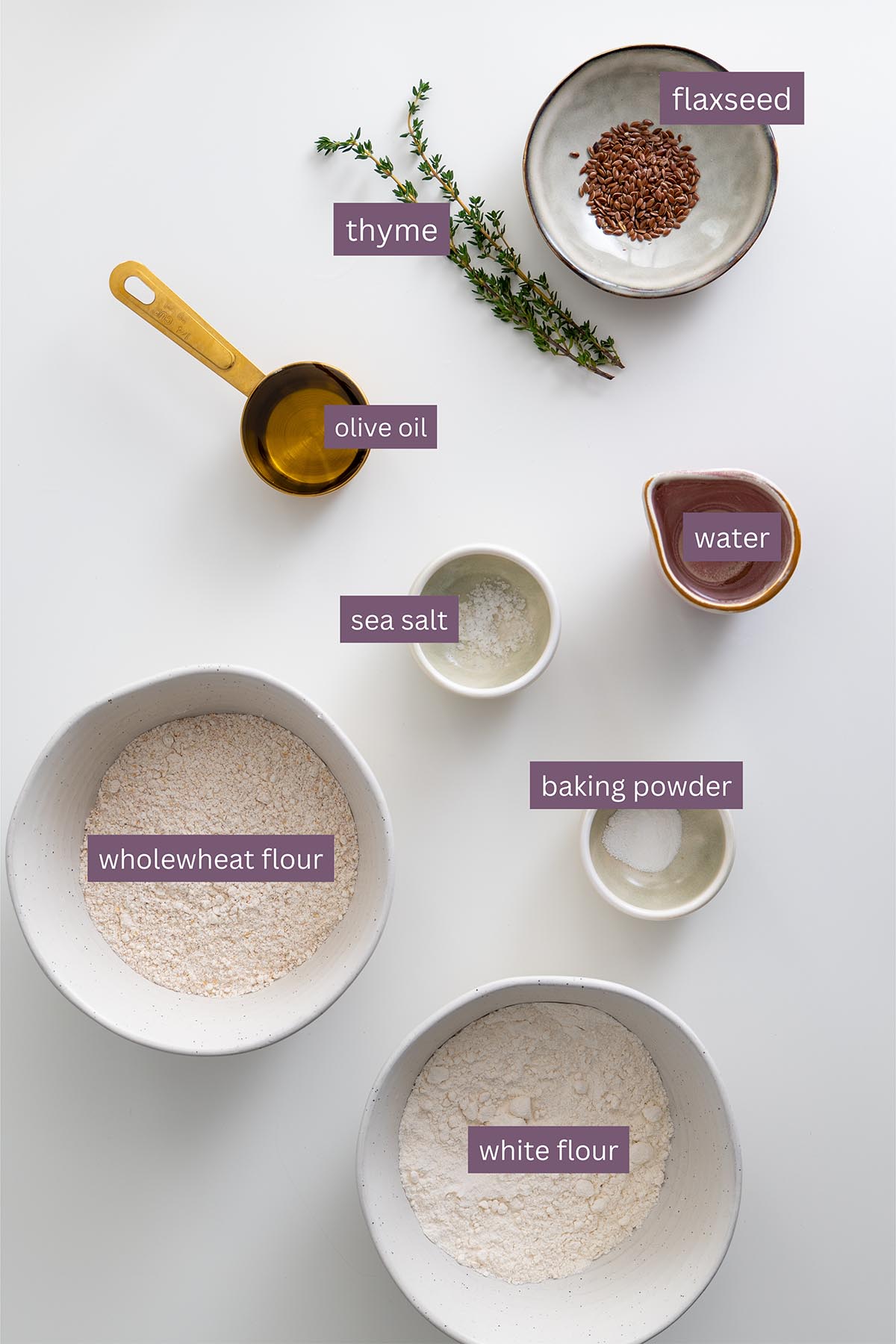 Flatlay of ingredients including flour, oil, baking powder, and herbs