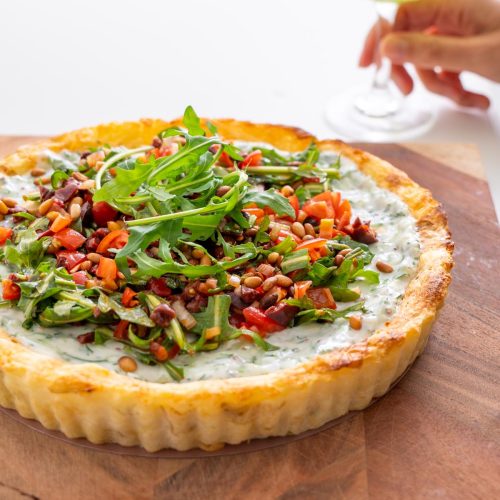 Sarah Cobacho holding drink with a slice of Mediterranean potato tart