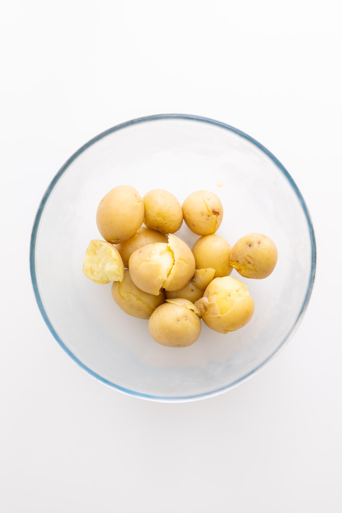 Boiled baby potatoes in a clear bowl after cooling