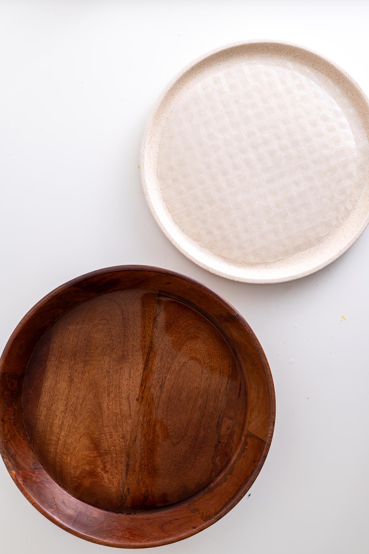 Rice paper sheet on a plate beside a bowl of water ready for dipping