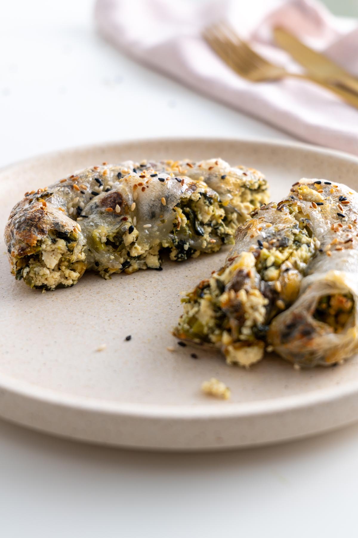 Close-up of baked rice paper roll spanakopita sliced open on a plate